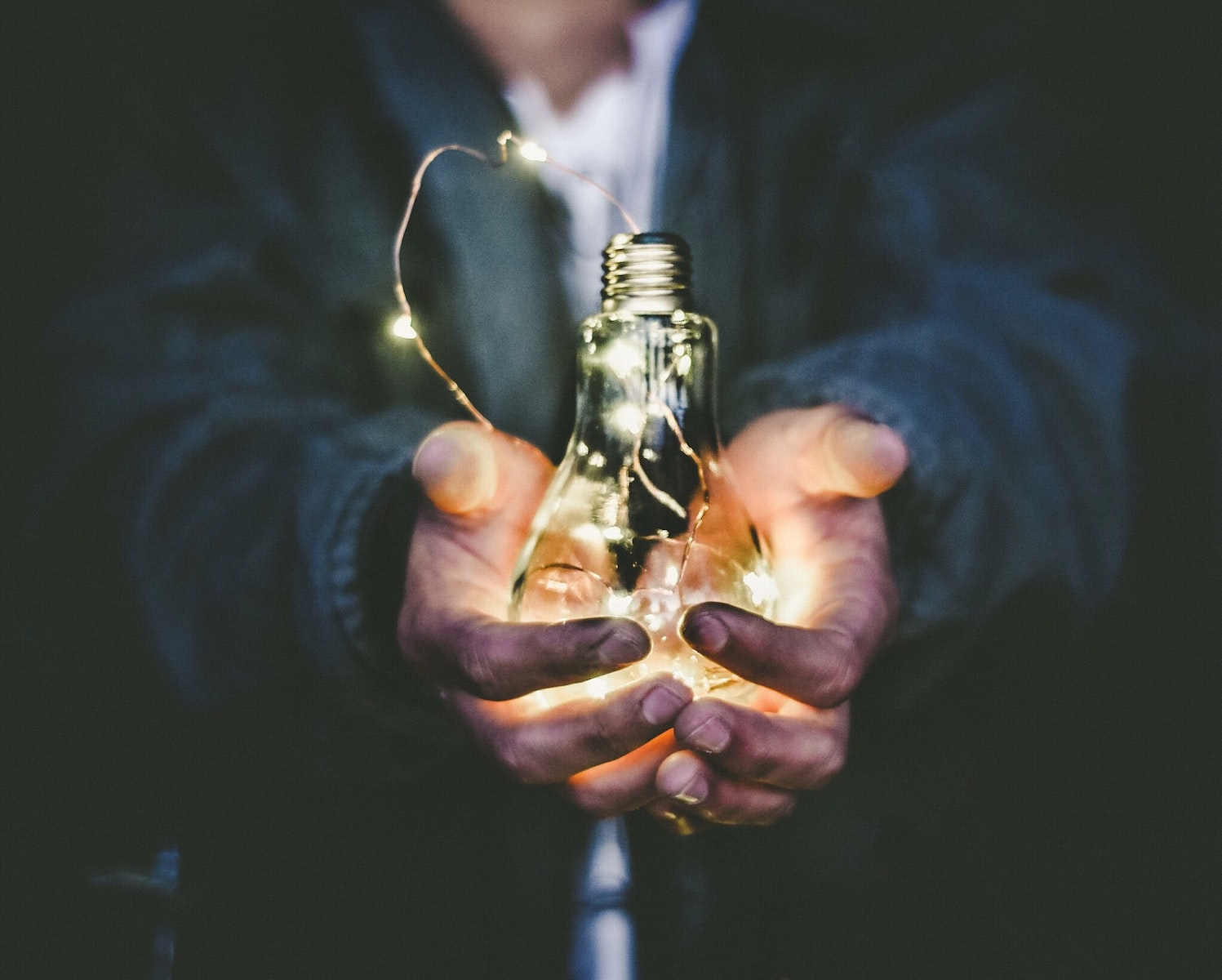 man holding incandescent bulb